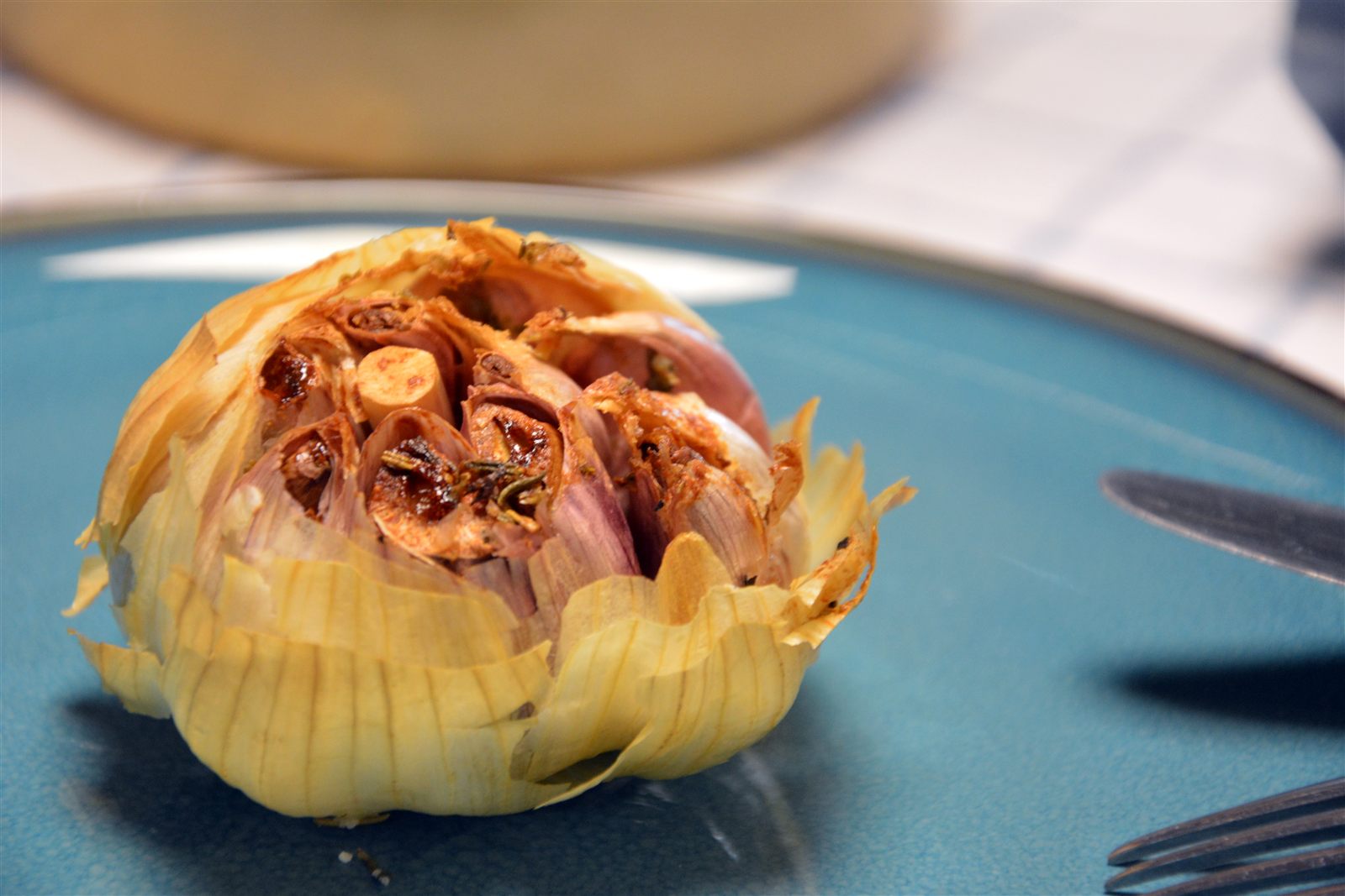 Ganze geröstete Knoblauchknollen in einer Auflaufform mit Butter und Rosmarin