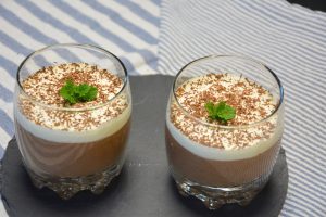 Zwei Gläser selbst gemachte Mousse au Chocolat mit Sahnehaube, Schokoraspeln und frischer Minze